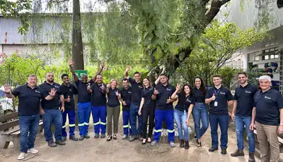 "Scott Bader team in matching uniforms gathered outdoors at industrial facility, showcasing company culture" [G]