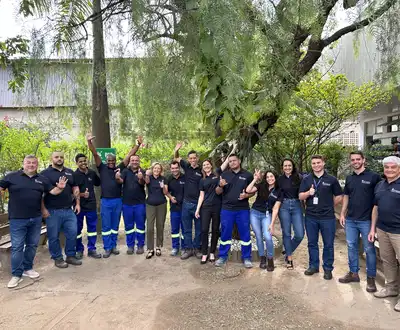 "Scott Bader team in matching uniforms gathered outdoors at industrial facility, showcasing company culture" [G]