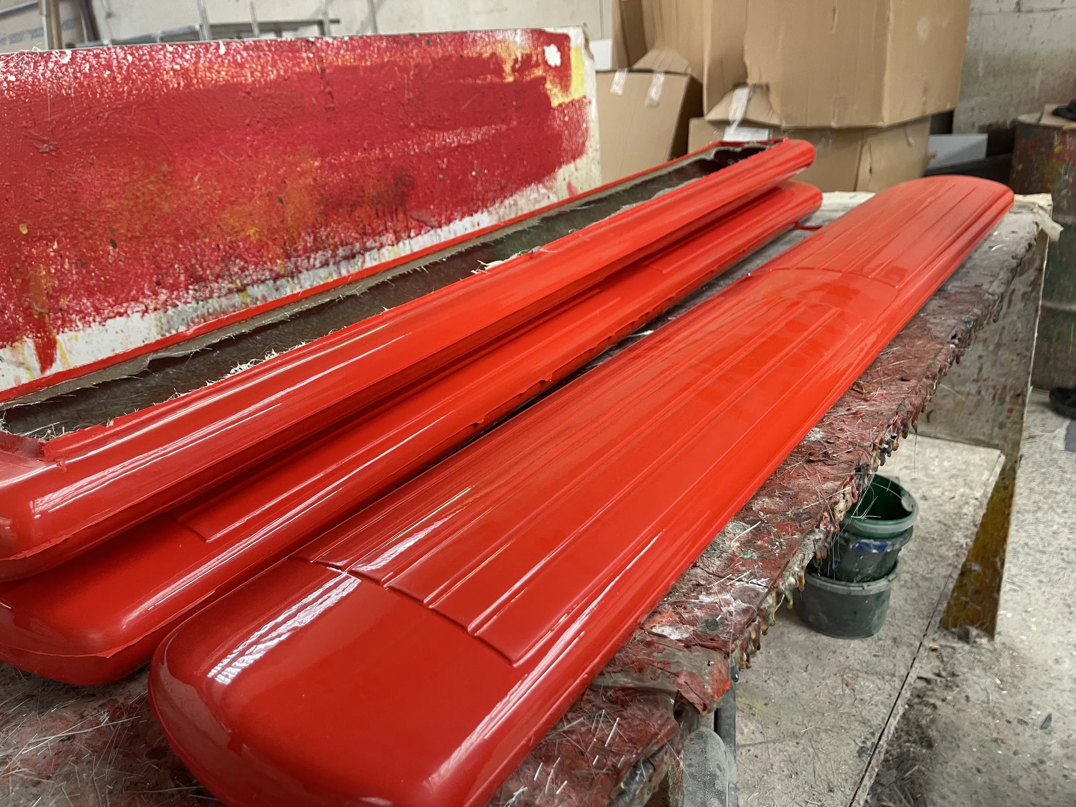 "Bright red composite panels with glossy gelcoat finish in Scott Bader manufacturing facility, showcasing high-quality resins application" [G]