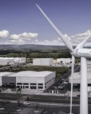 "Aerial view of industrial facility with wind turbine in foreground, showcasing Scott Bader's commitment to sustainable manufacturing" [G]
