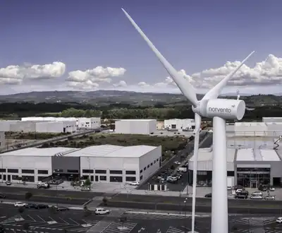 "Aerial view of industrial facility with wind turbine in foreground, showcasing Scott Bader's commitment to sustainable manufacturing" [G]