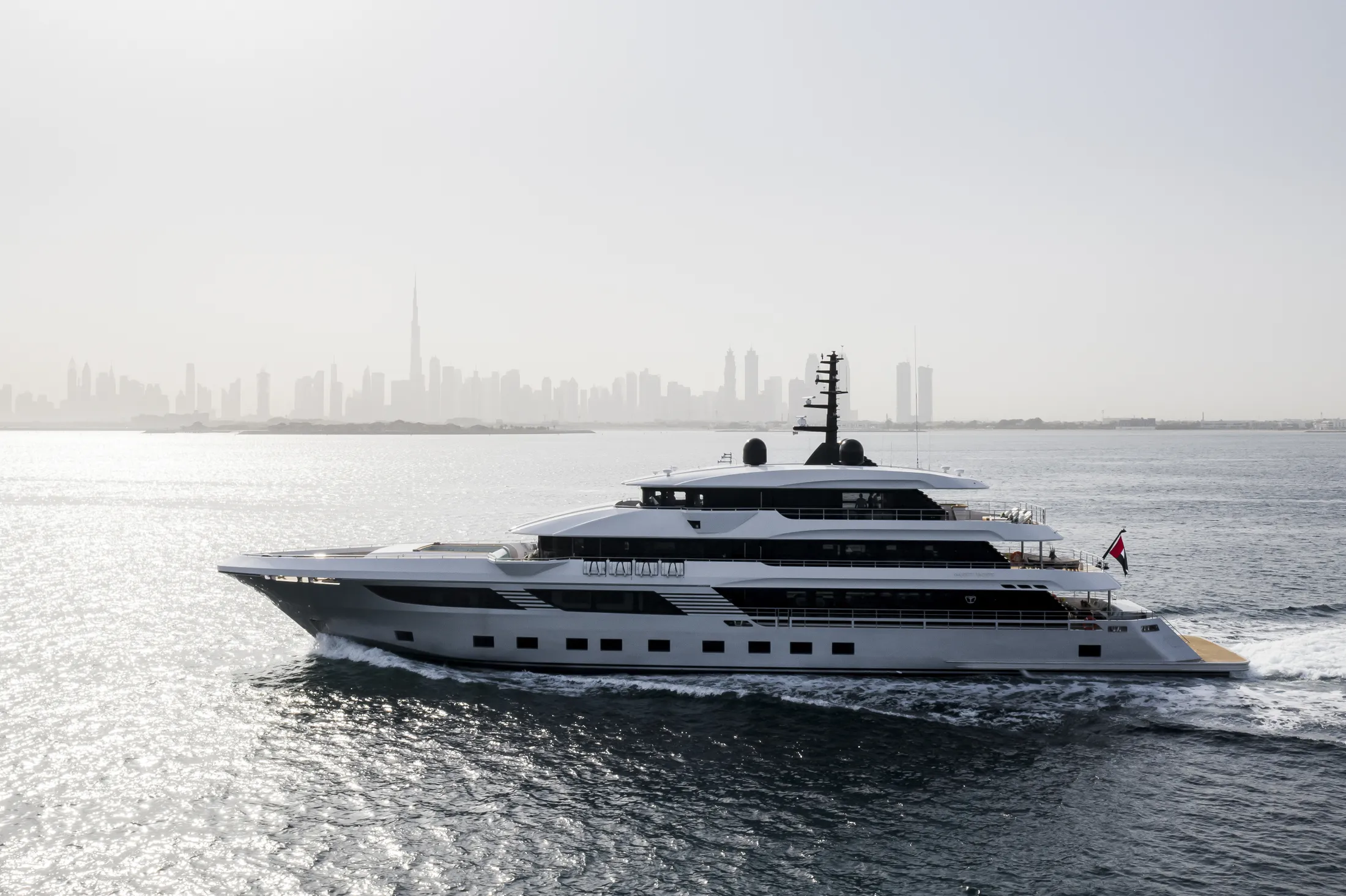 "Luxury yacht cruising on water with city skyline backdrop, featuring Scott Bader gelcoats and composites for marine applications" [G]