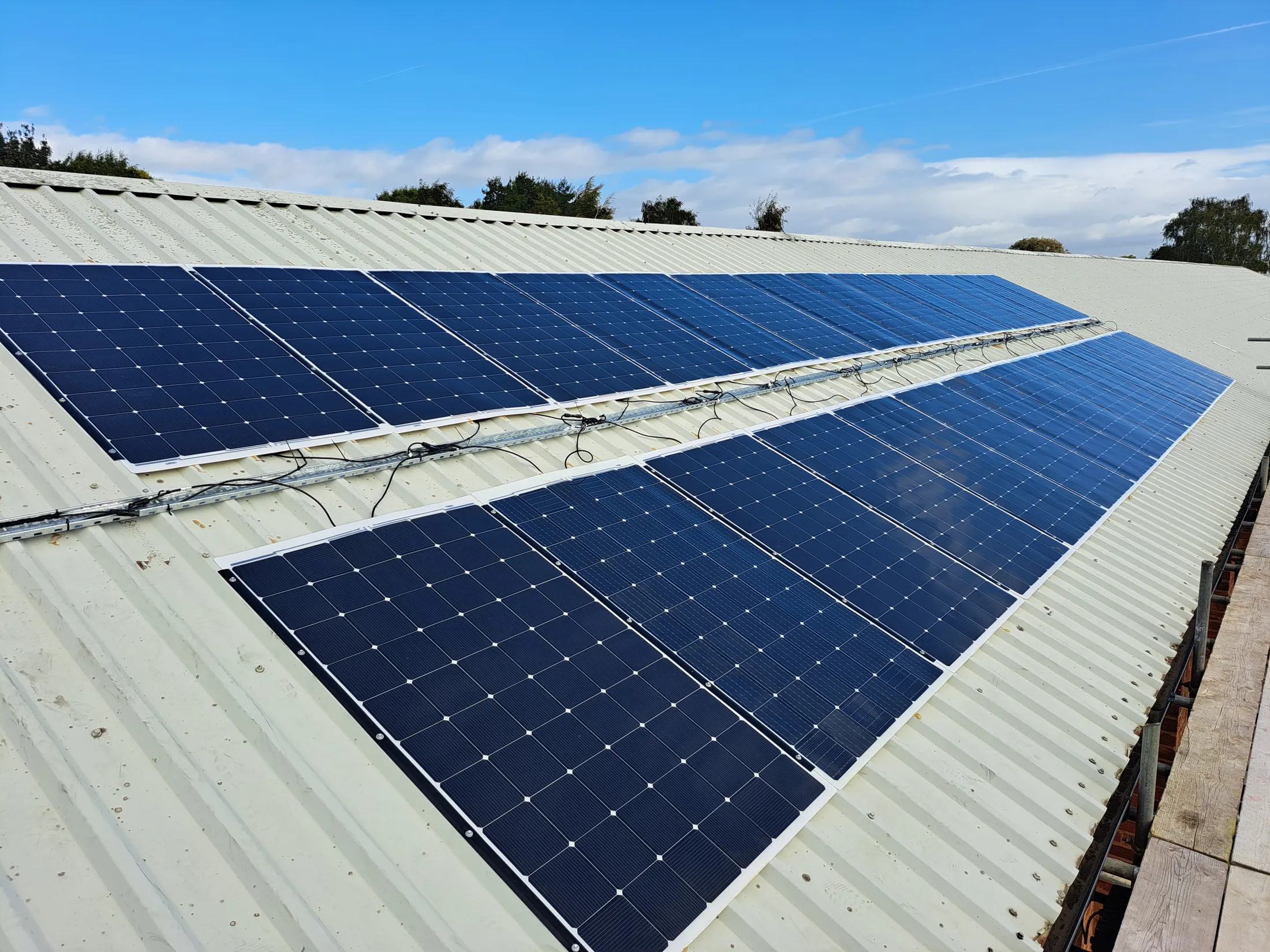 Solar panels installed on a metal roof structure under blue sky, showcasing durable composite materials from Scott Bader [G]
