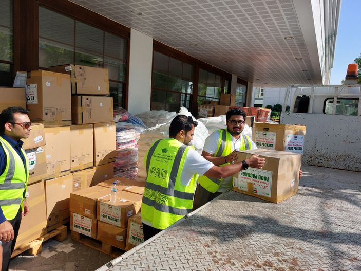 "Workers in safety vests handling boxed materials at Scott Bader distribution facility, showcasing logistics for composites and resins" [G]
