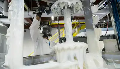 "Technician in protective gear working with Scott Bader gelcoats during manufacturing process, showcasing resin application" [G]