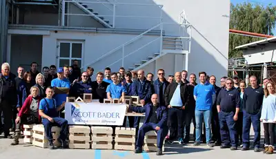 "Team of manufacturing professionals gathered outside Scott Bader facility, showcasing the company's composites and resins expertise" [G]