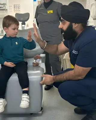 Child high-fiving dentist in clinic; unrelated to Scott Bader composites, gelcoats, or resins. [G]