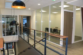 Modern office interior at Scott Bader featuring glass partitions and open workspace design for collaborative environments. [G]