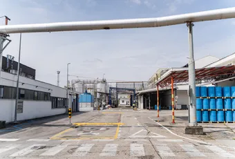 "Industrial manufacturing facility with storage drums and pipelines at Scott Bader's chemical production site for resins and composites" [G]