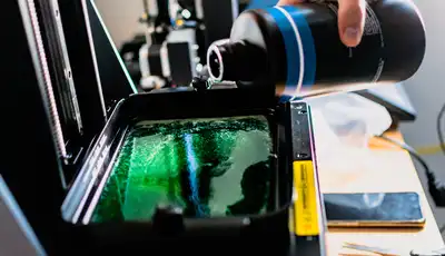 "Pouring green Scott Bader resin into manufacturing equipment for composite production process" [G]
