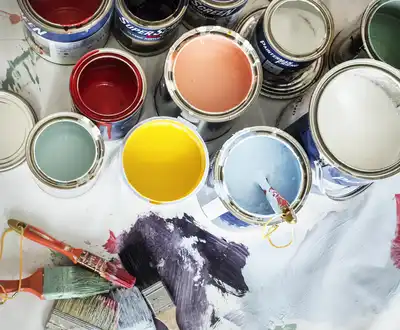 "Colorful gelcoats and resins from Scott Bader displayed in open paint cans with brushes on paint-splattered surface" [G]