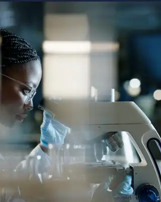 "Laboratory technician examining materials at microscope in Scott Bader research facility for advanced composites and resins" [G]