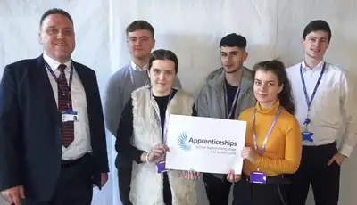 "Group of professionals at an apprenticeship event with Scott Bader representatives showcasing career opportunities in composites and resins" [G]