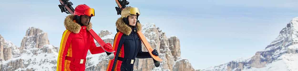 Twee vrouwen in retro skipakken in de besneeuwde bergen