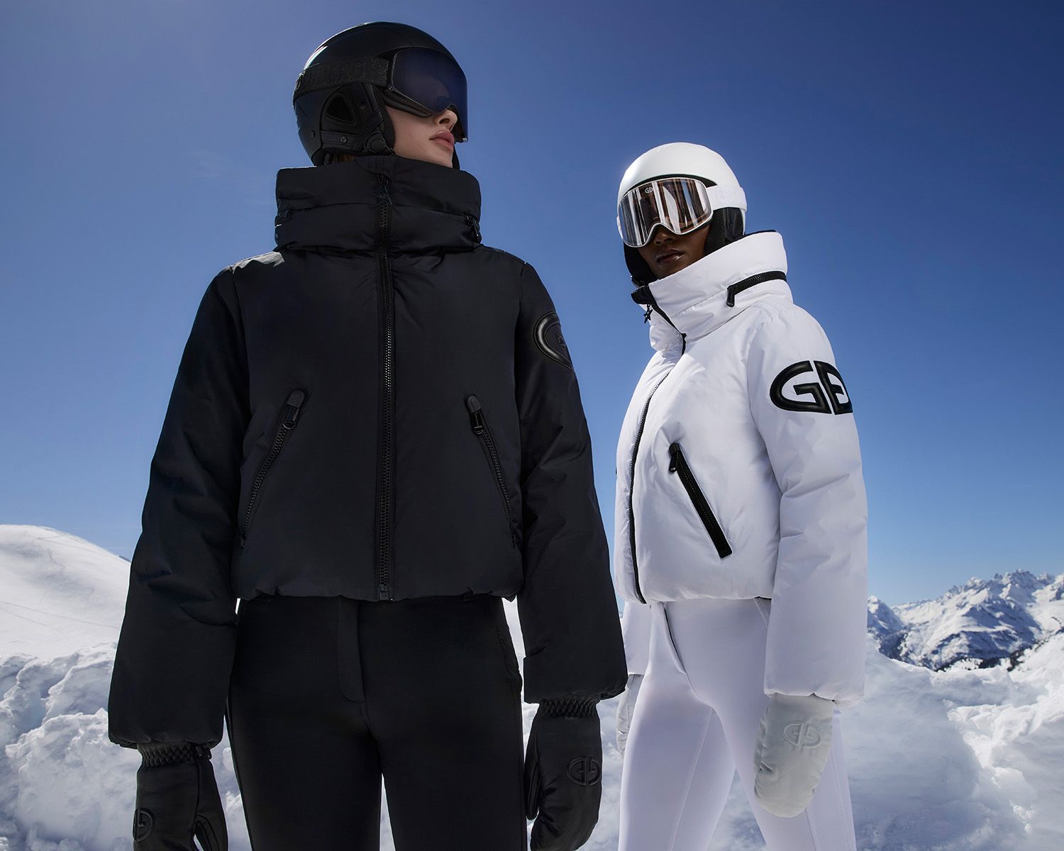 Vrouwen in de piste met witte en zwarte skikleding aan