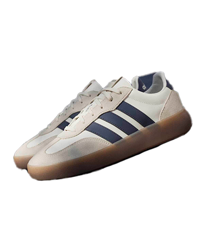 Sneakers Beige and white sneakers with blue stripes and a gum sole, displayed on a dark surface.