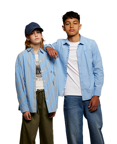 Kids Two young individuals wearing blue striped shirts; one in a cap and olive pants, the other in jeans, pose confidently against a neutral background.