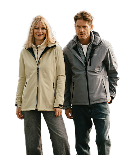 Jassen A woman in a beige jacket and a man in a gray jacket stand smiling, both wearing casual outdoor clothing.