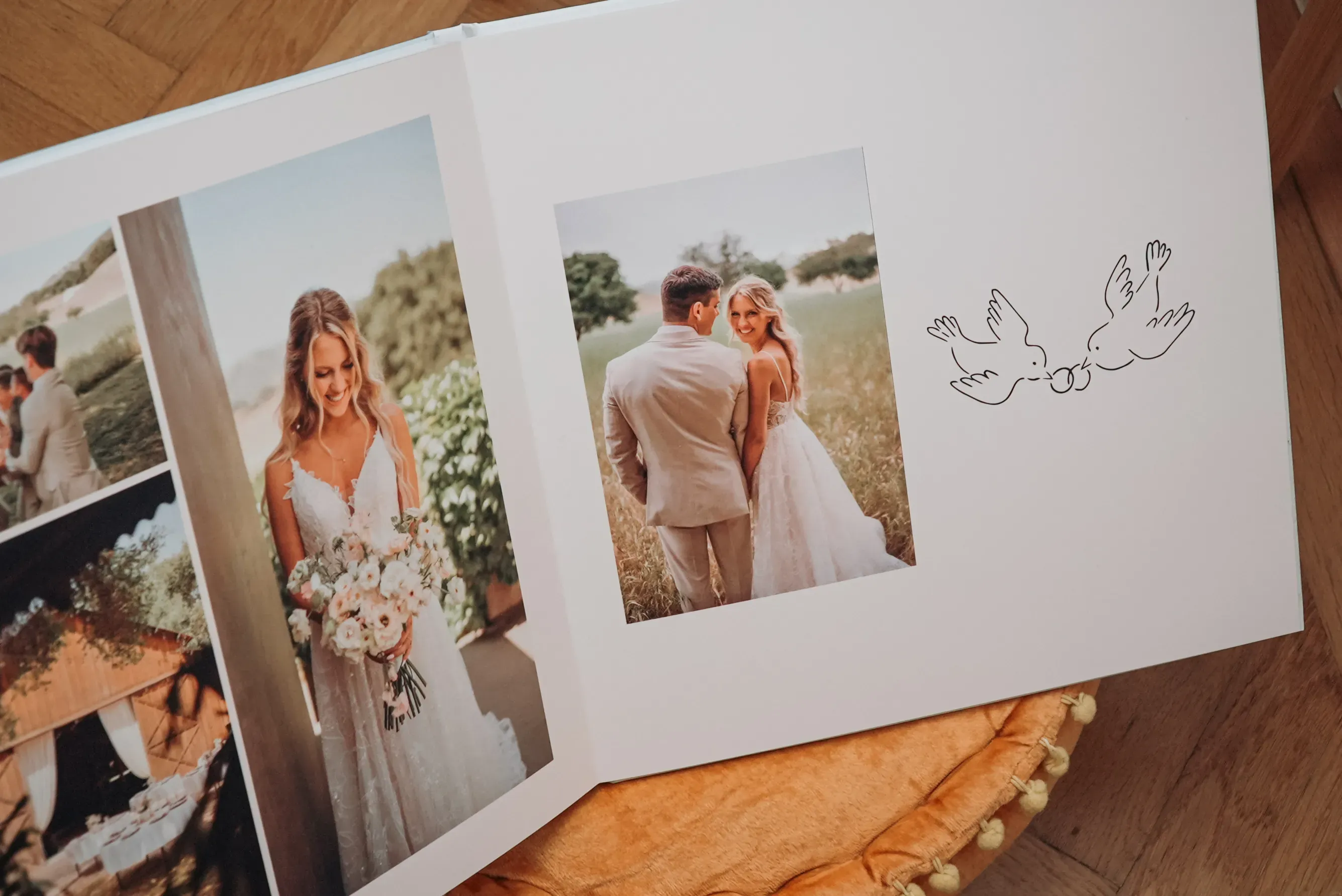 Open wedding photo album with a bride and groom, floral bouquet, and sketched birds.