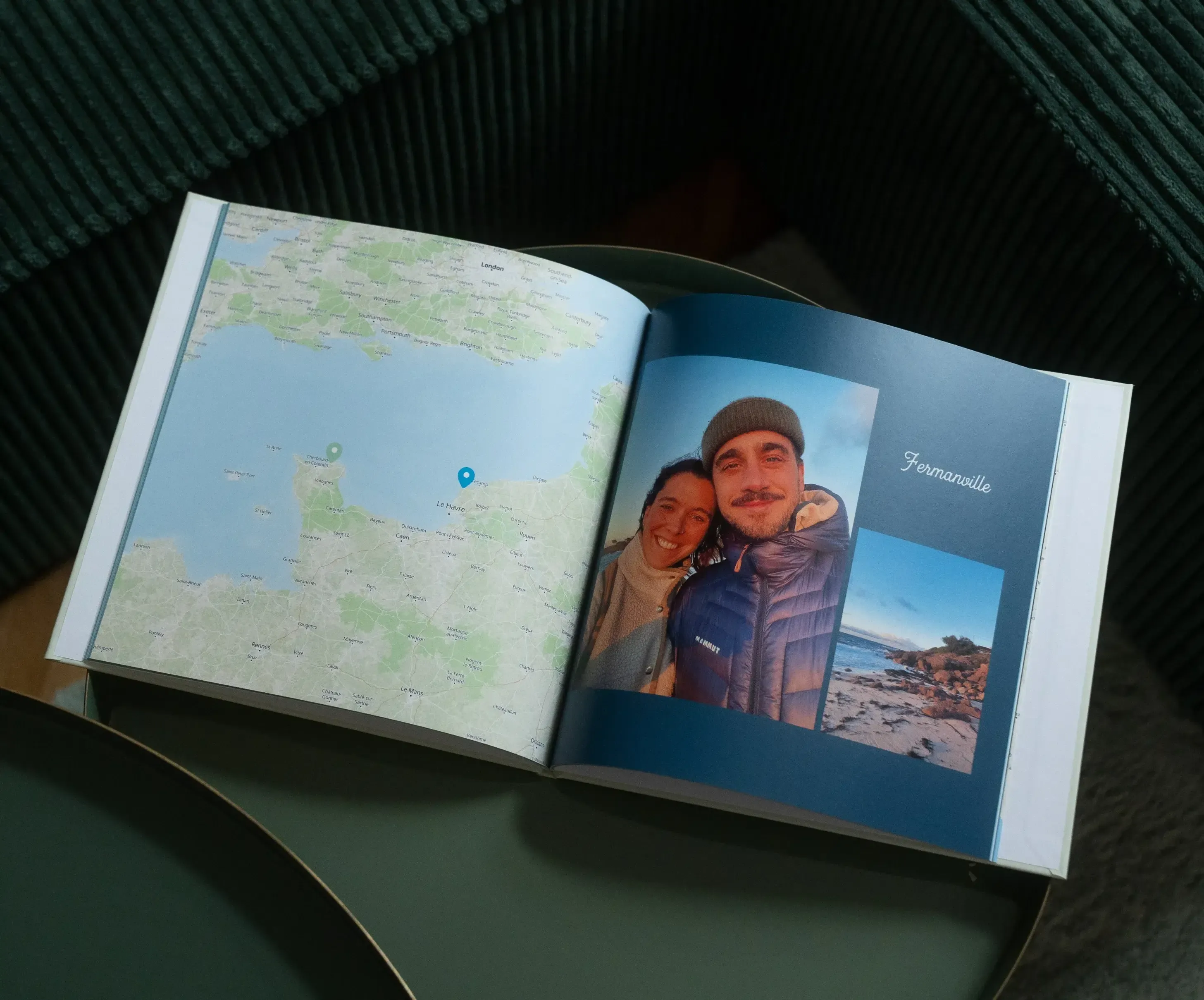 Open photo album on a table showing a map on the left and two people smiling by the beach on the right.