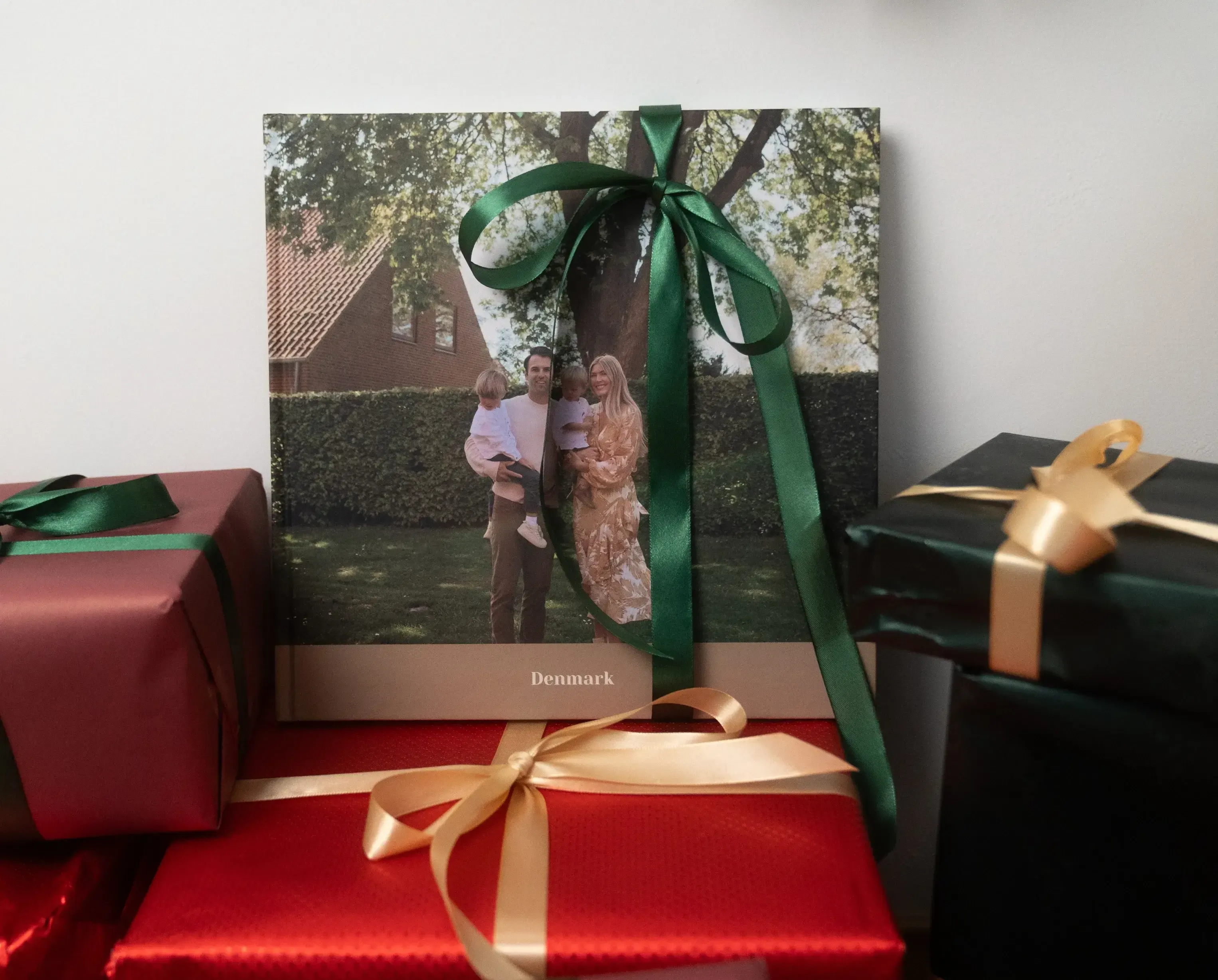Gift-wrapped photo album with a family picture and the word "Denmark," surrounded by other wrapped presents.