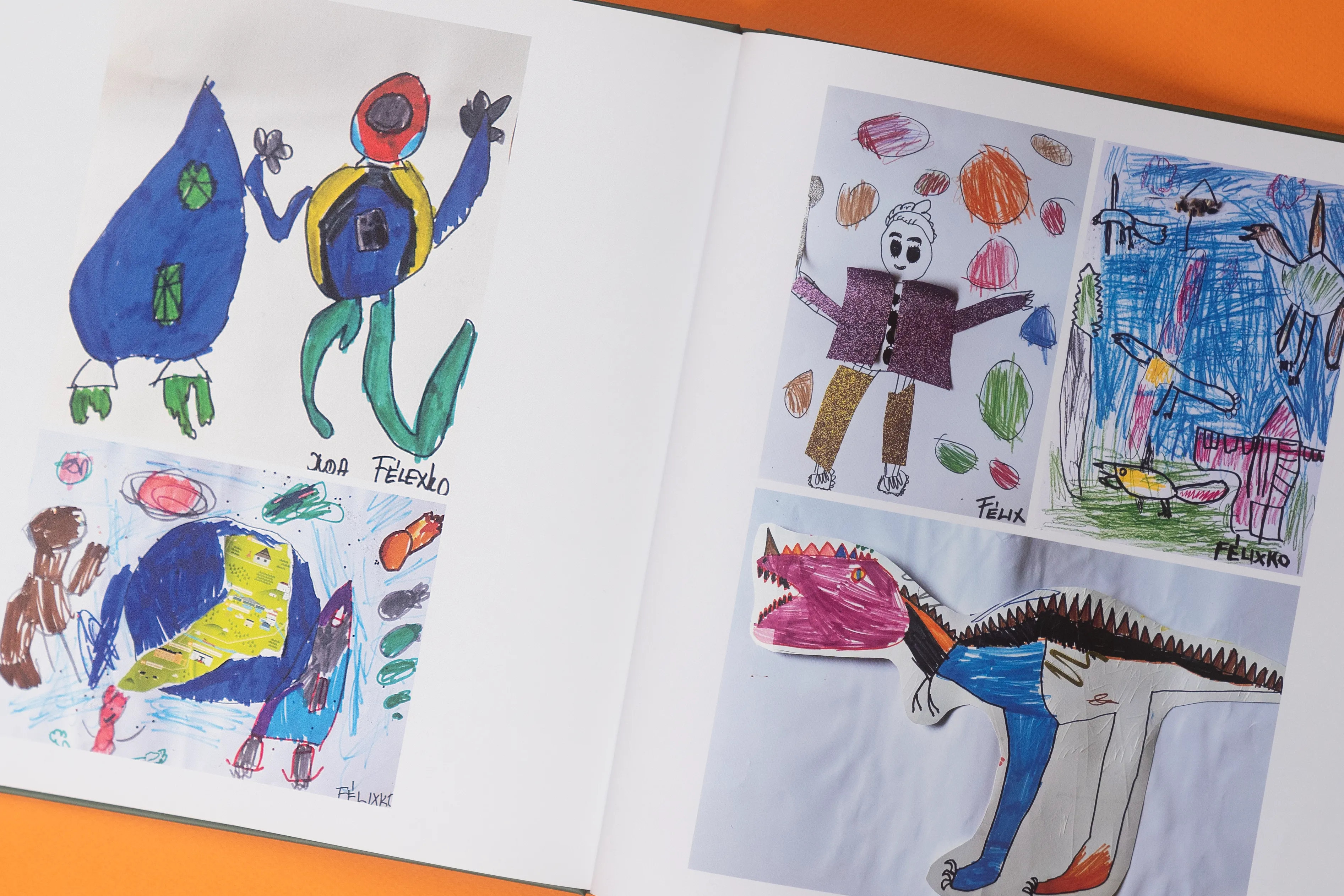 Ein aufgeschlagenes Fotobuch mit farbenfrohen Kinderzeichnungen von Fantasiewesen und Figuren. Die Seiten enthalten jeweils vier verschiedene Kunstwerke.