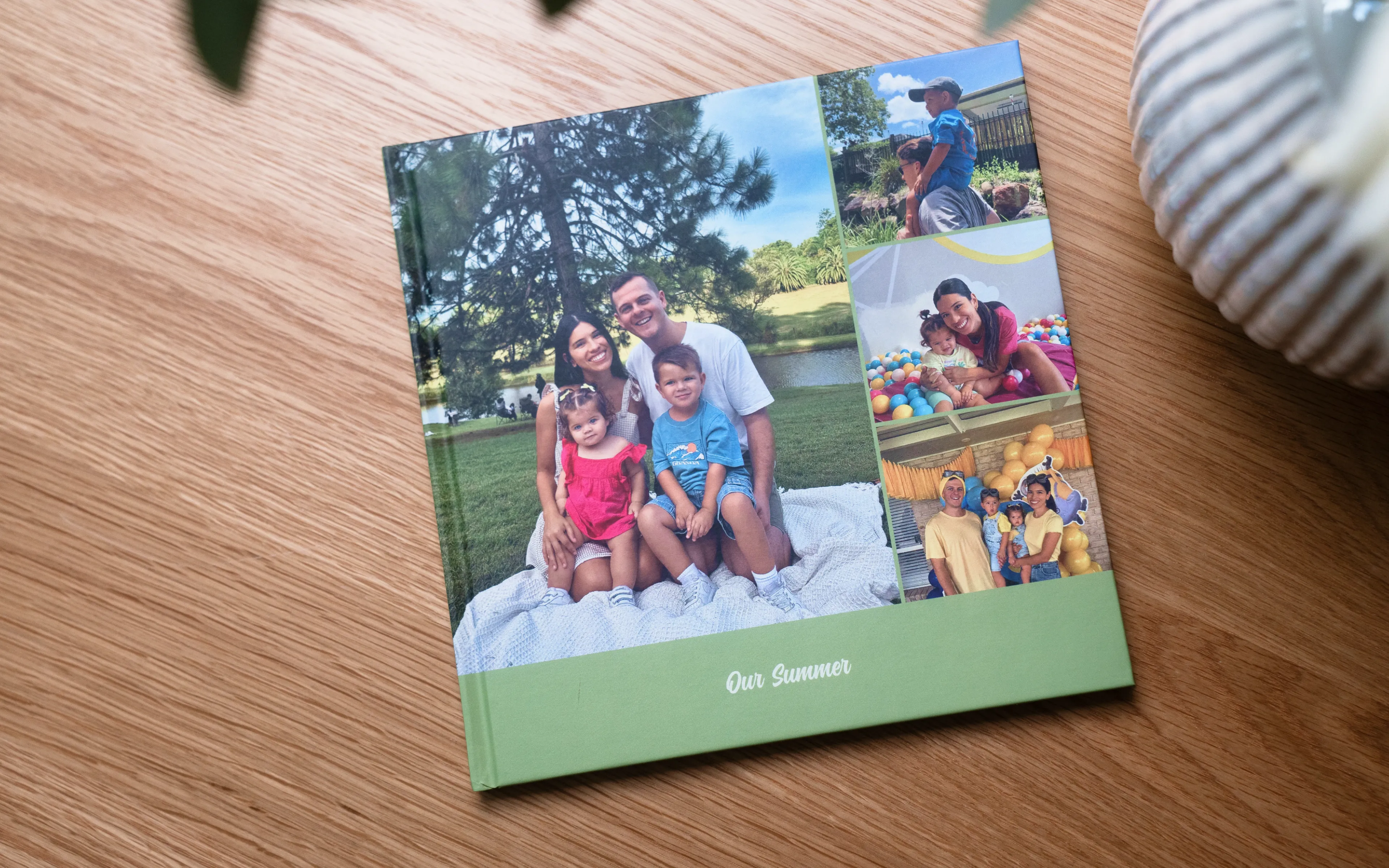 Fotoalbum mit dem Titel „Unser Sommer“ mit einem Familienfoto und einer Collage von Outdoor- und Karnevalsmomenten auf Holz.