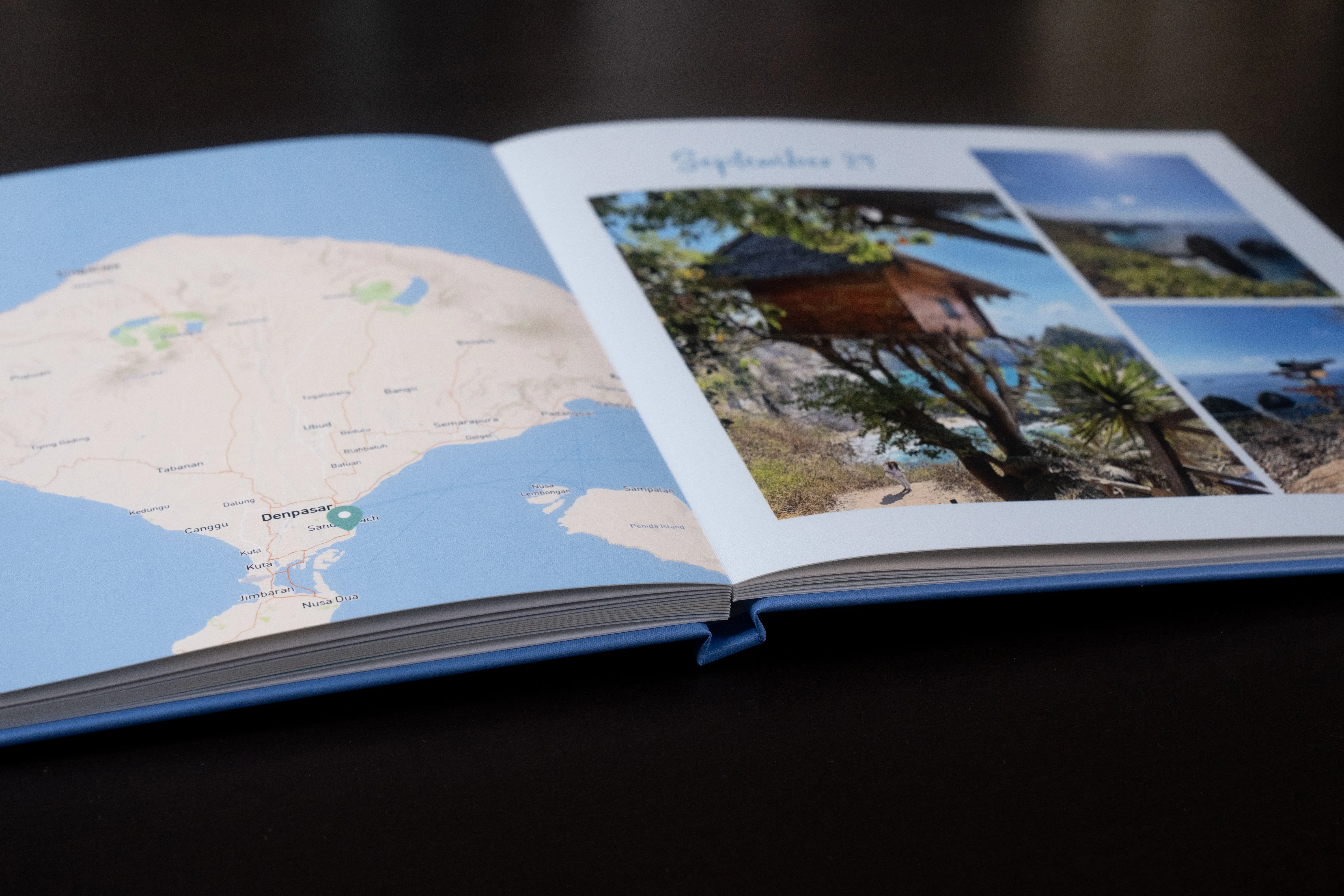 Open layflat photo book showing a map on the left page and a collage of outdoor images with "September 19" written above on the right page.