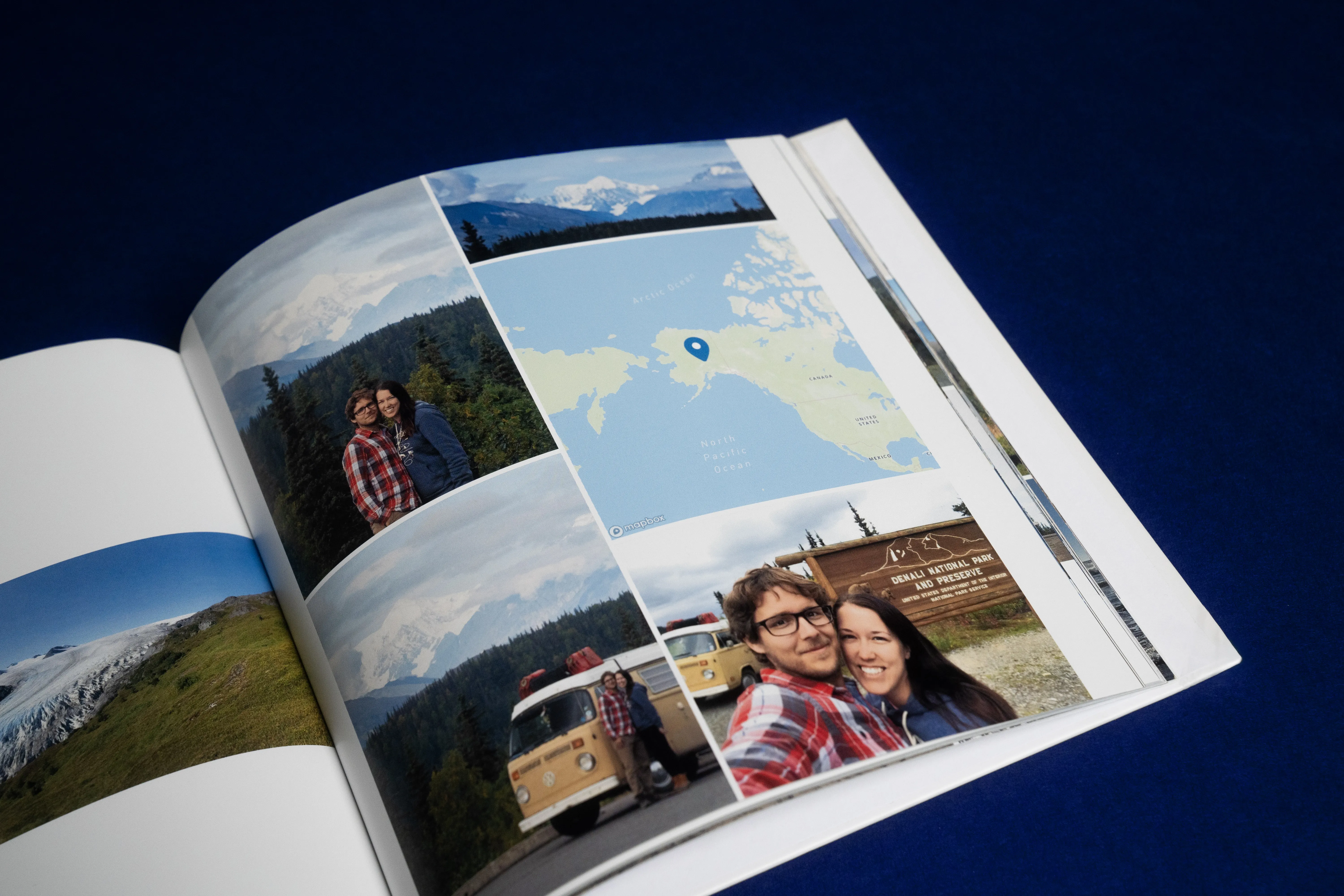 Open photo album showing travel photos, including a couple, landscapes, and a map with a location pin, against a dark blue background.