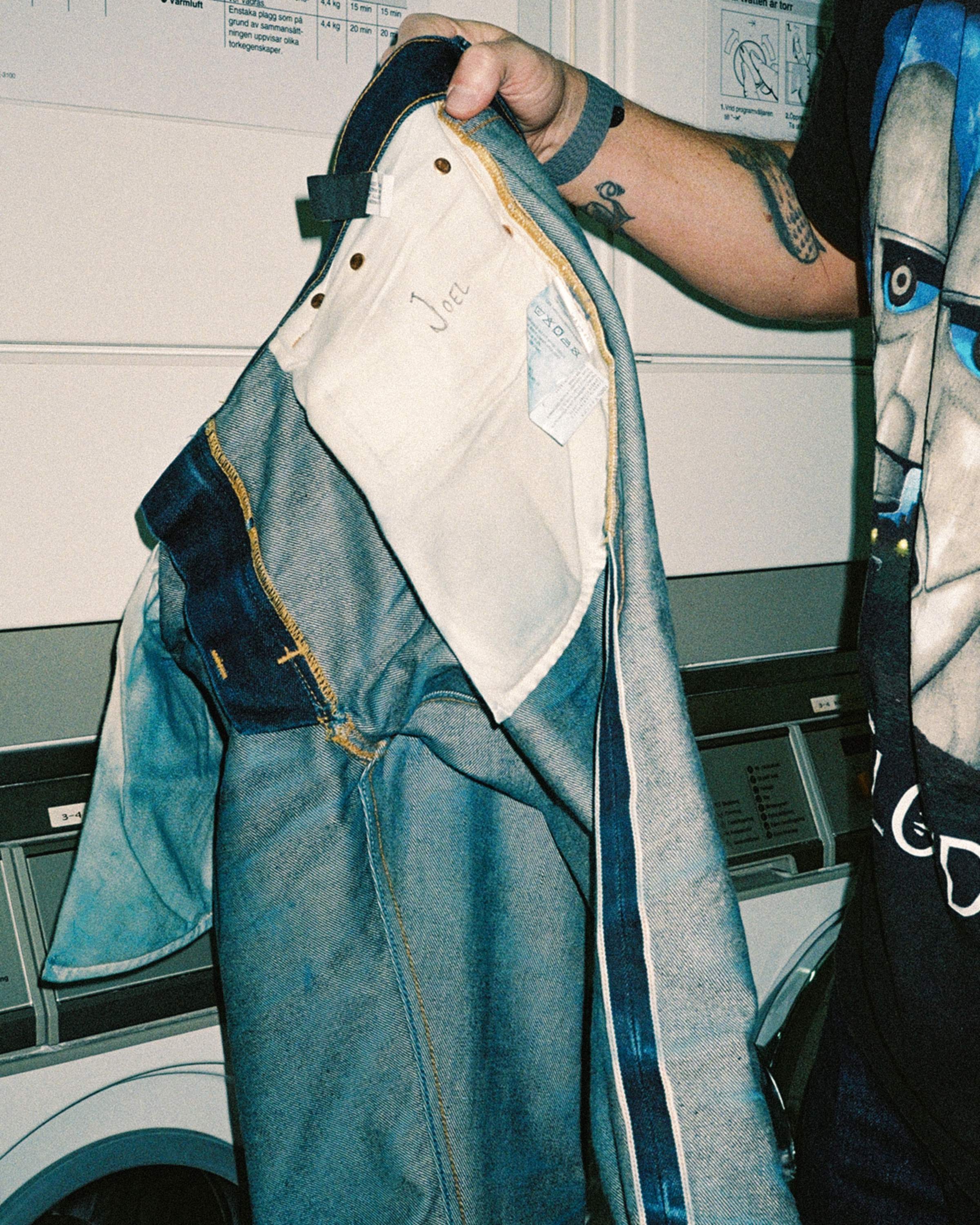 Inside-out jeans exposing the care label, pocket bags and interior seams.