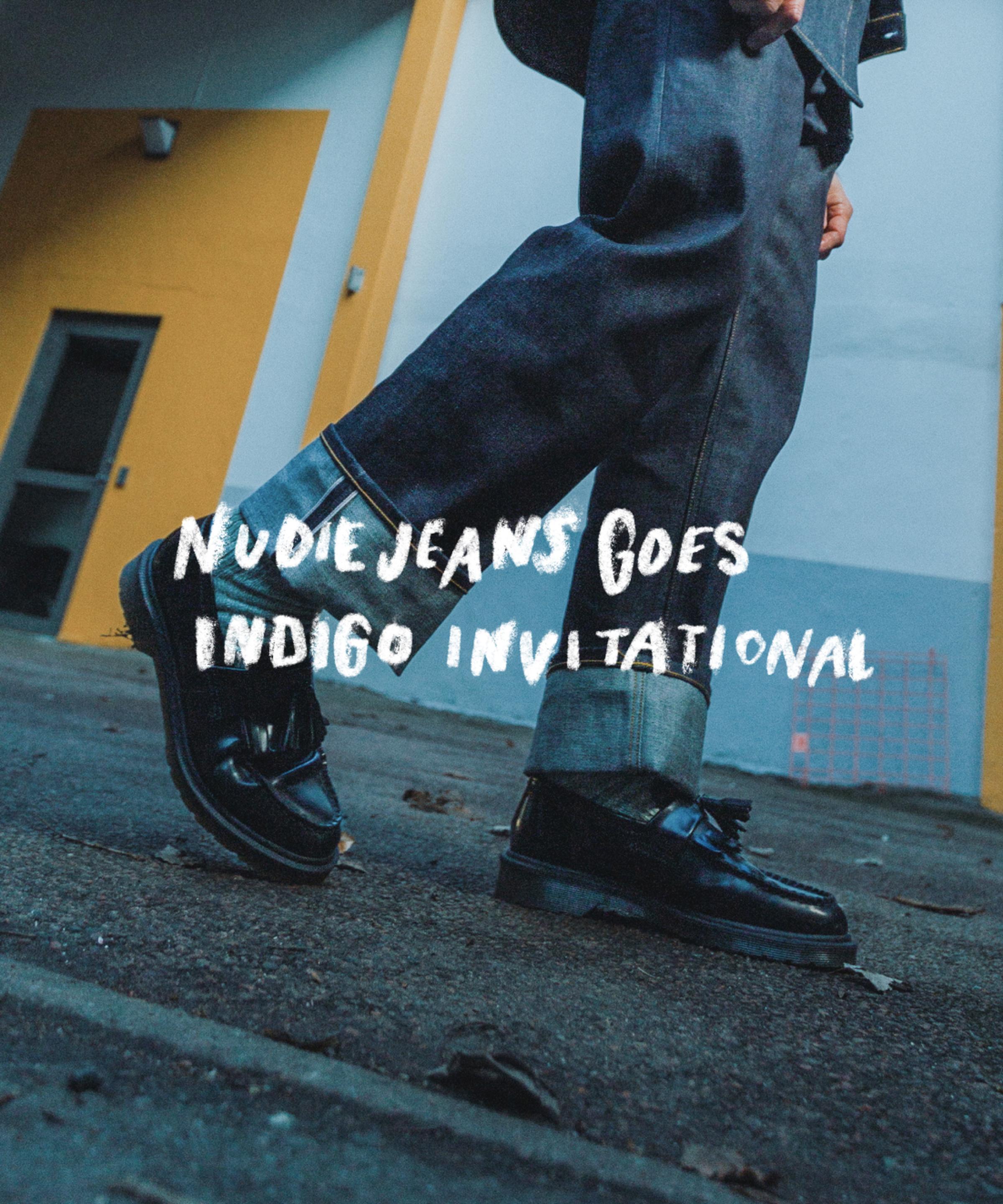 Person in denim walking, wearing black shoes, with "Nudie Jeans Goes Indigo Invitational" text overlay. Urban background with yellow accents.