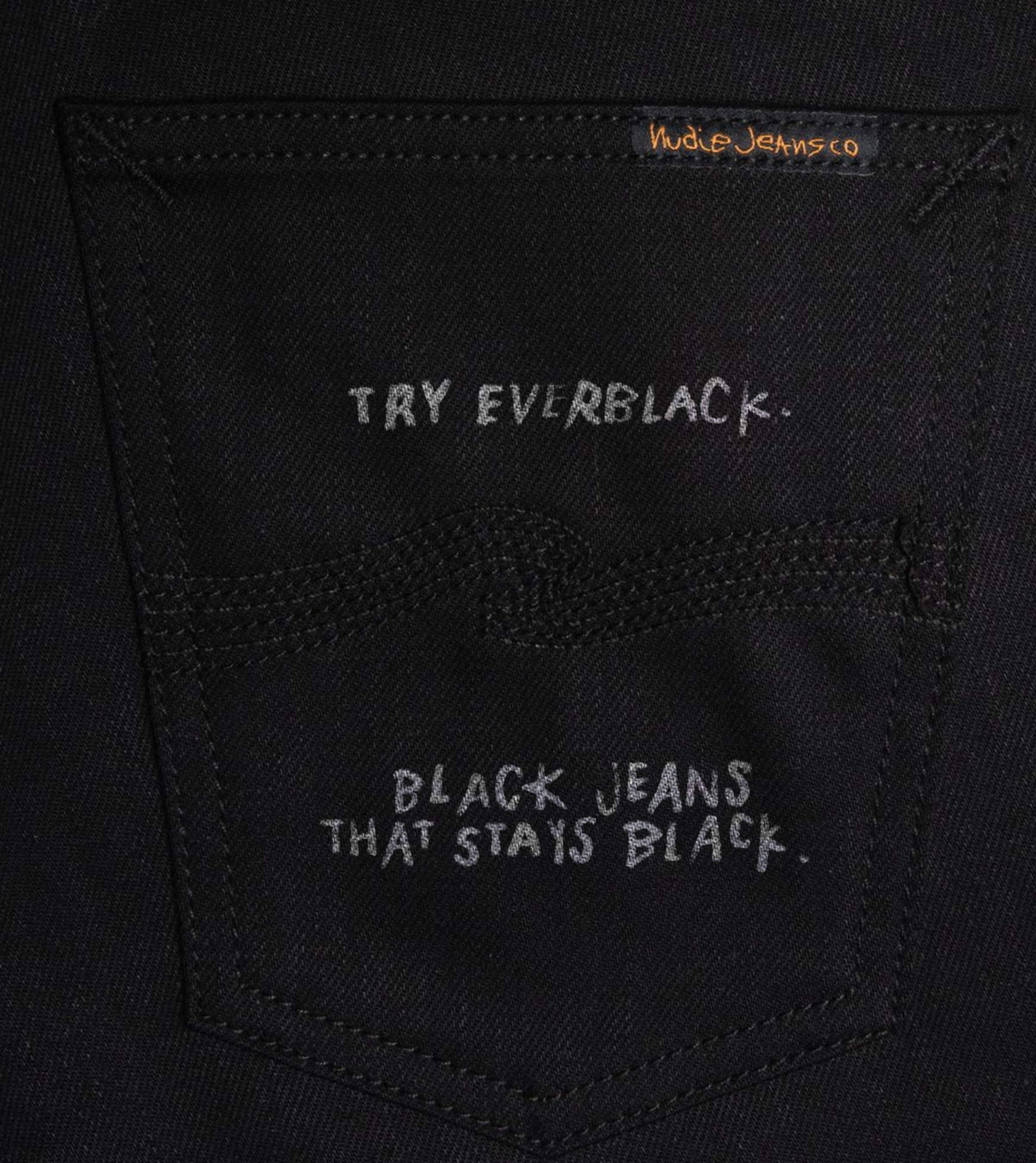 Close-up of black Nudie Jeans back pocket with handwritten text, "Try Everblack. Black jeans that stays black."