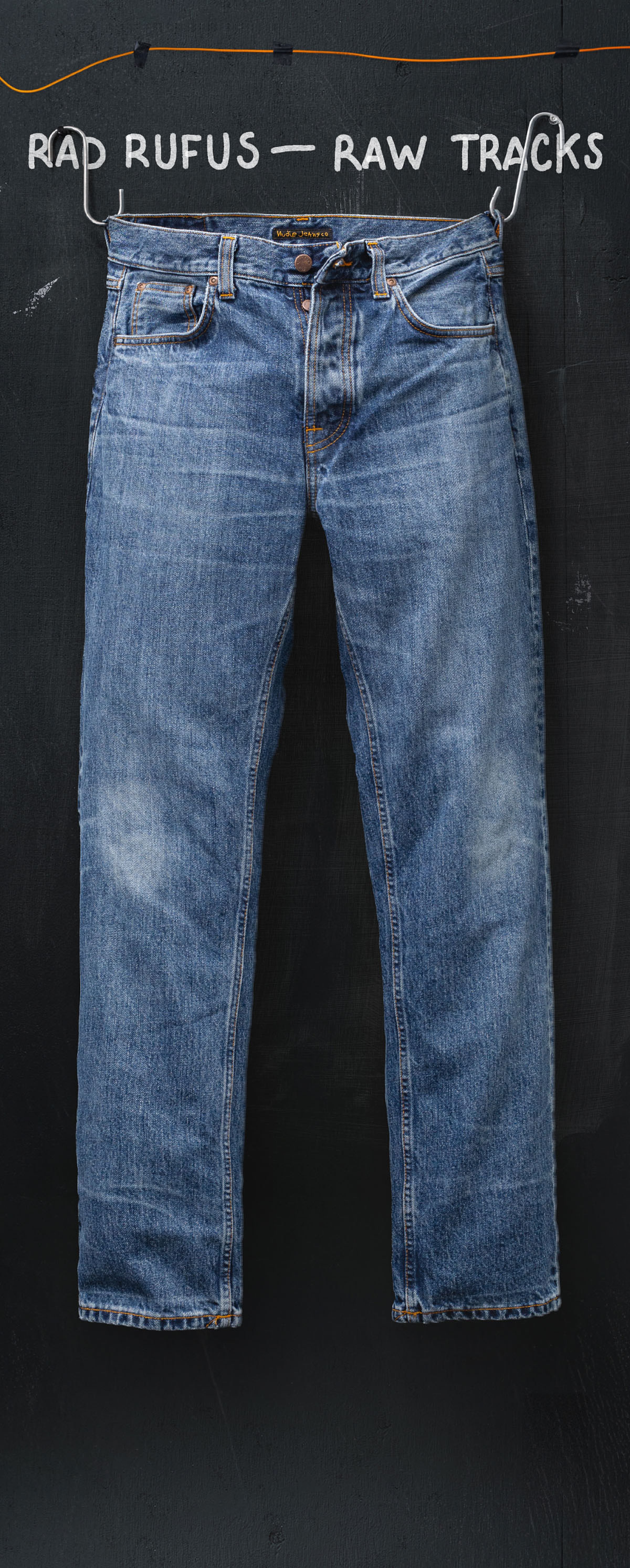 Faded blue jeans hanging against a dark background with the text "RAD RUFUS — RAW TRACKS" above them.