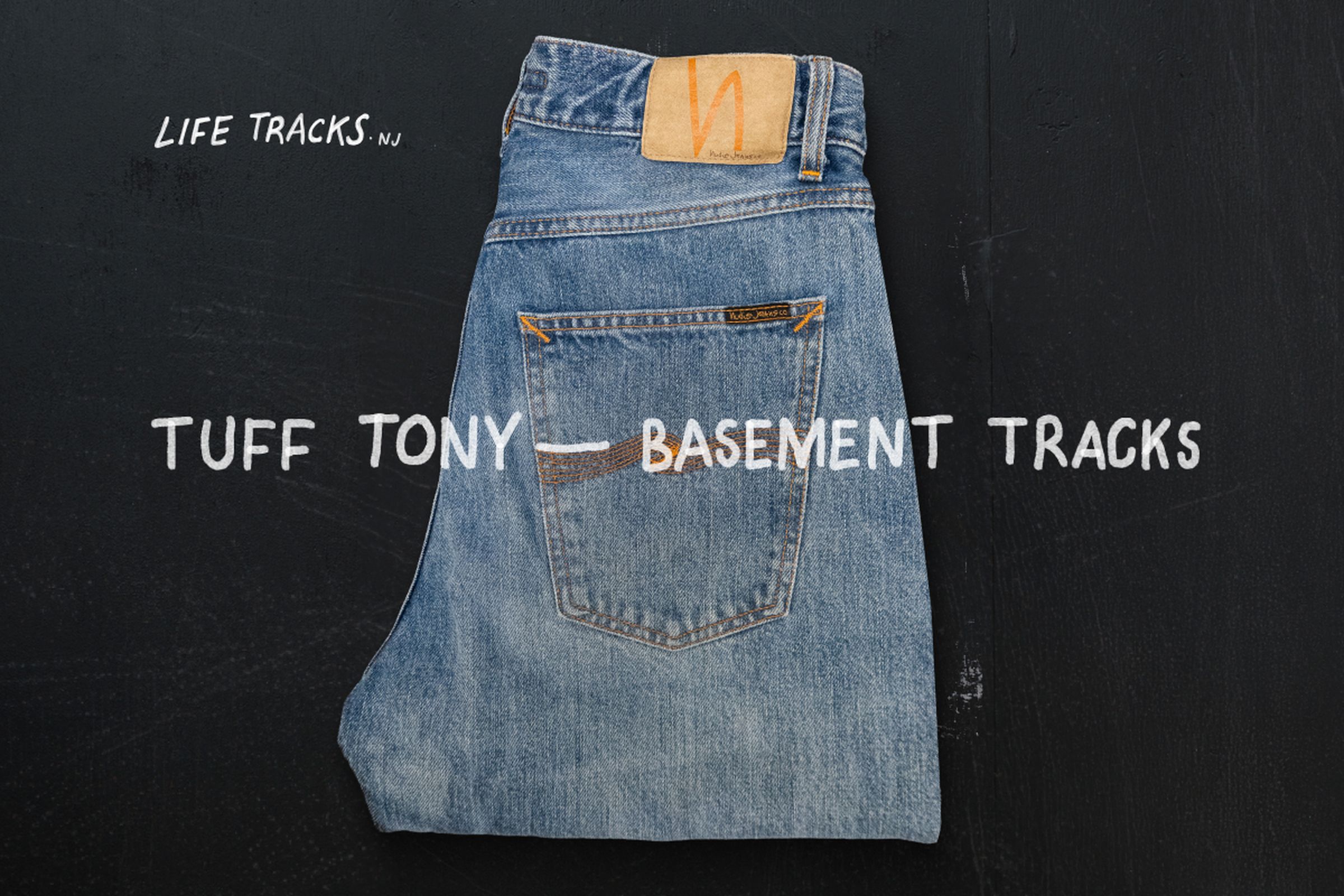 Folded blue jeans on a dark background with text: "Tuff Tony — Basement Tracks" and "Life Tracks NJ."