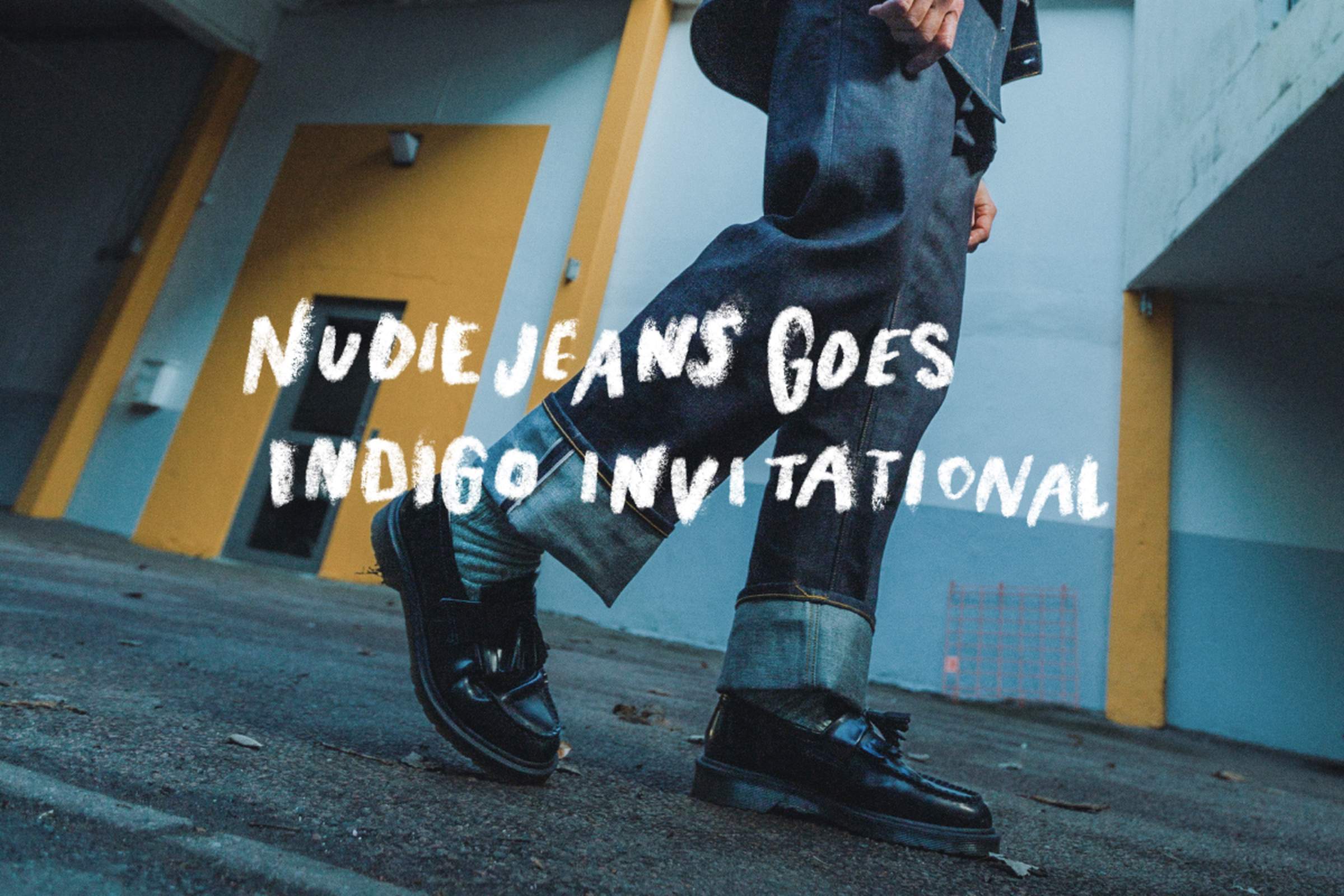 Person in denim walking, wearing black shoes, with "Nudie Jeans Goes Indigo Invitational" text overlay. Urban background with yellow accents.