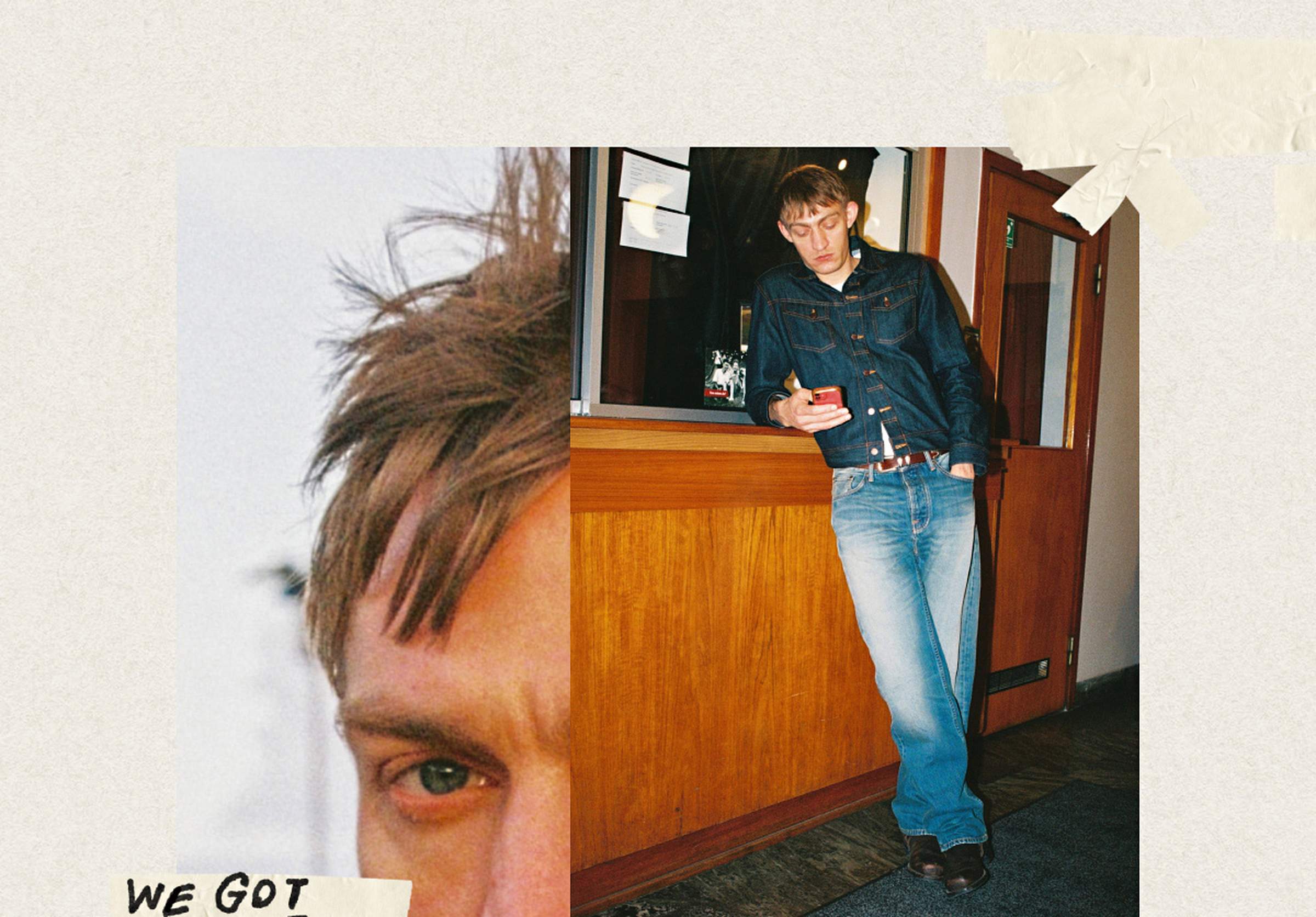 Person in denim jacket and jeans leans against a wooden counter, looking at a phone. Close-up of their eye on the left.