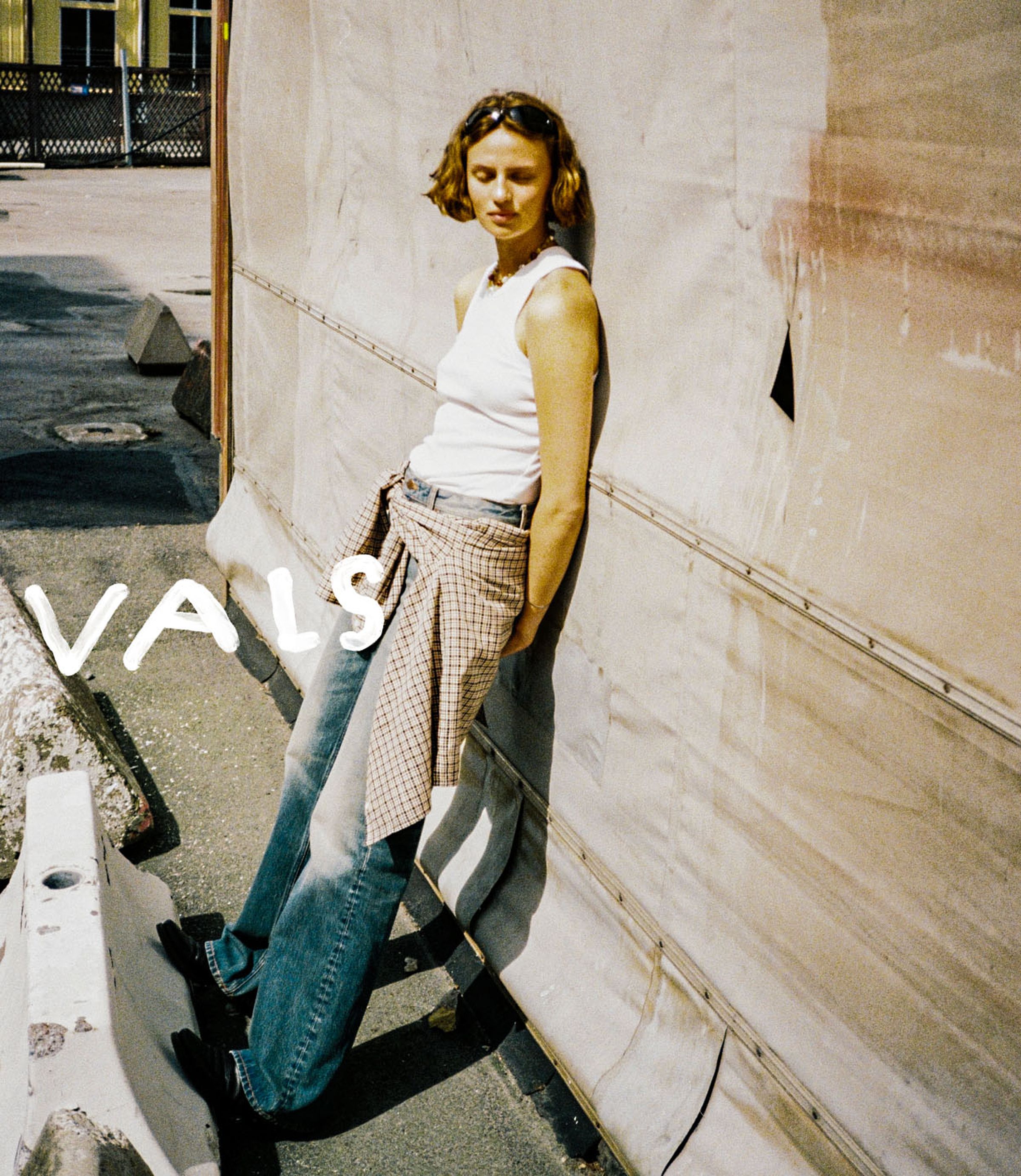 Women in a pair of Nudie jeans leans against a wall with "New Arrivals" text overlay.