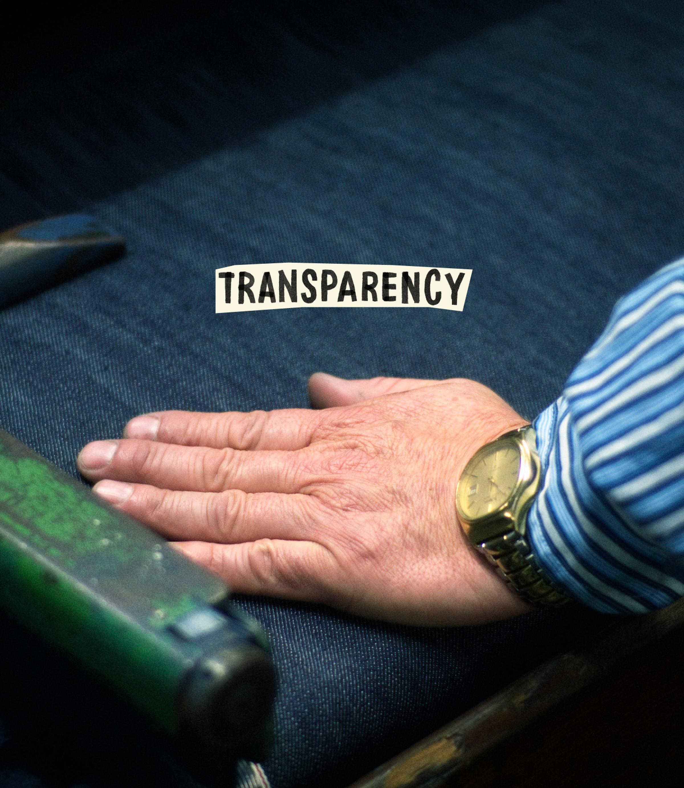 A hand with a watch rests on denim fabric with the word "TRANSPARENCY" above, suggesting attention to detail and honesty in craftsmanship.