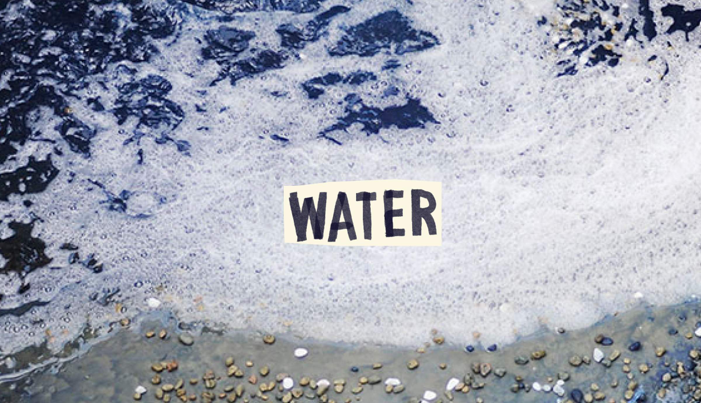 Foamy waves wash over pebbles on a beach, with the word "WATER" prominently displayed in the center.