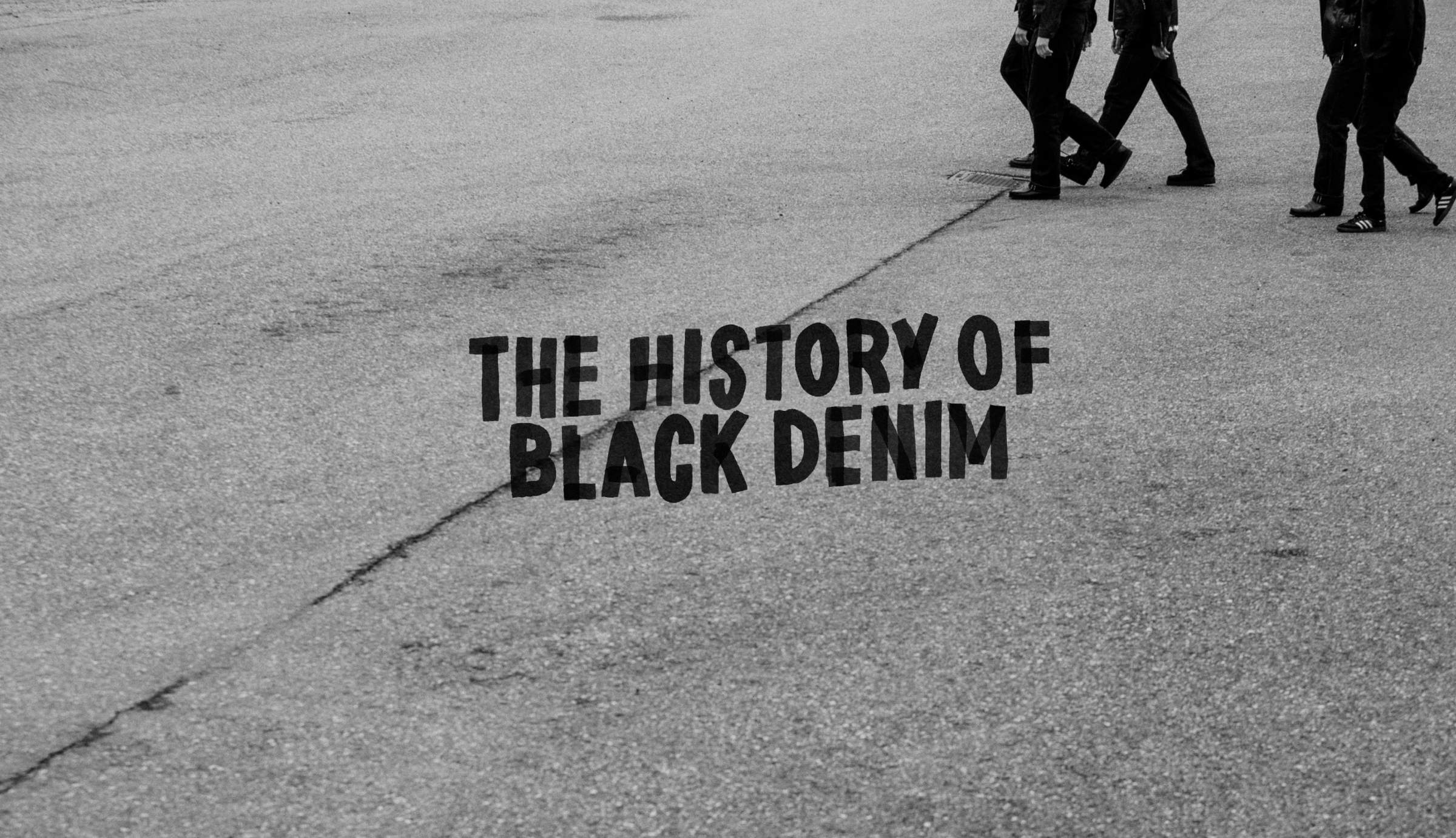 Black and white image of three people walking on a street with text "The History of Black Denim" on the pavement.
