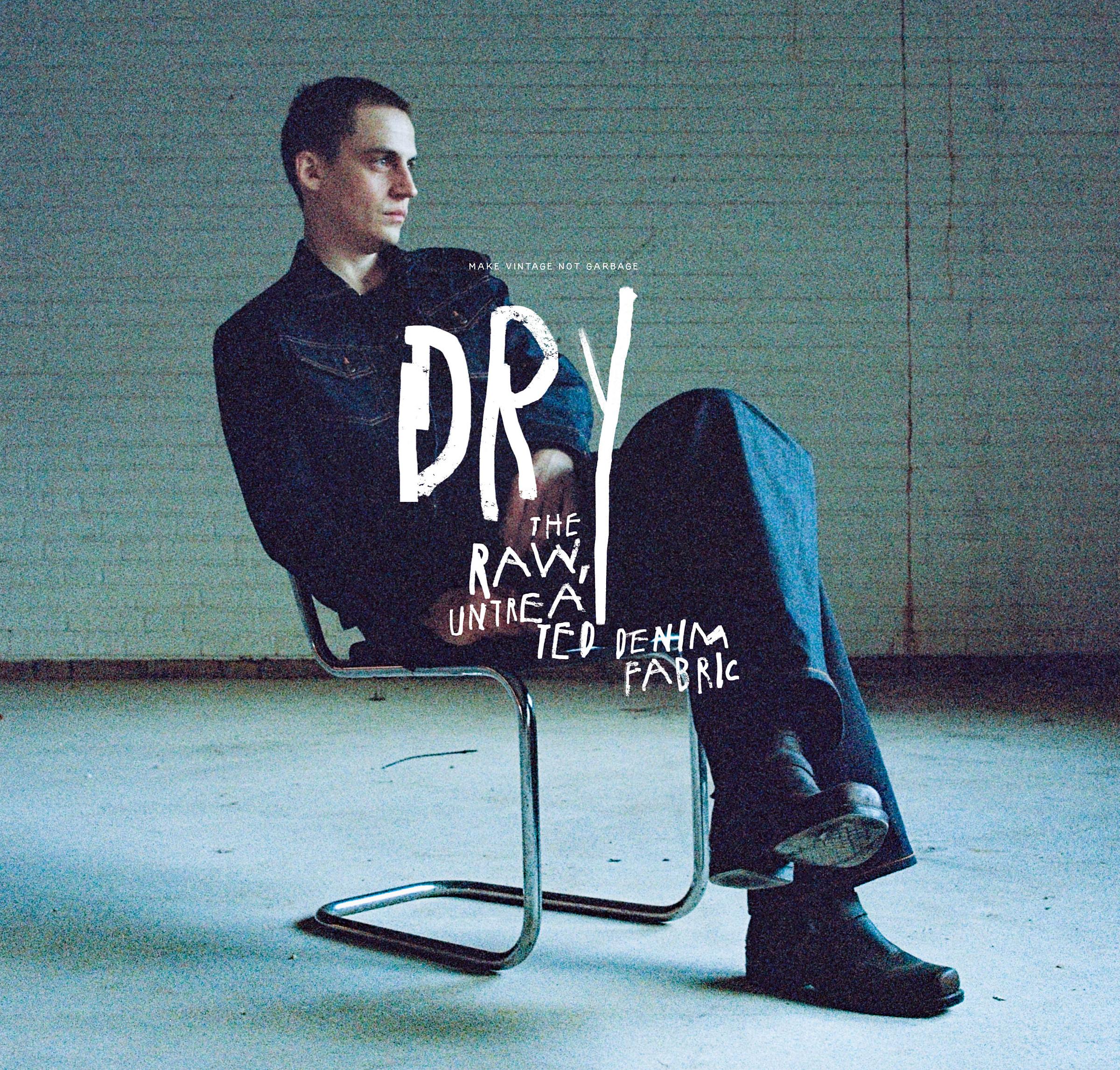 Person seated on a metal chair in a dimly lit room, wearing dark clothing. Text overlay reads "DRY: The Raw, Untreated Denim Fabric."