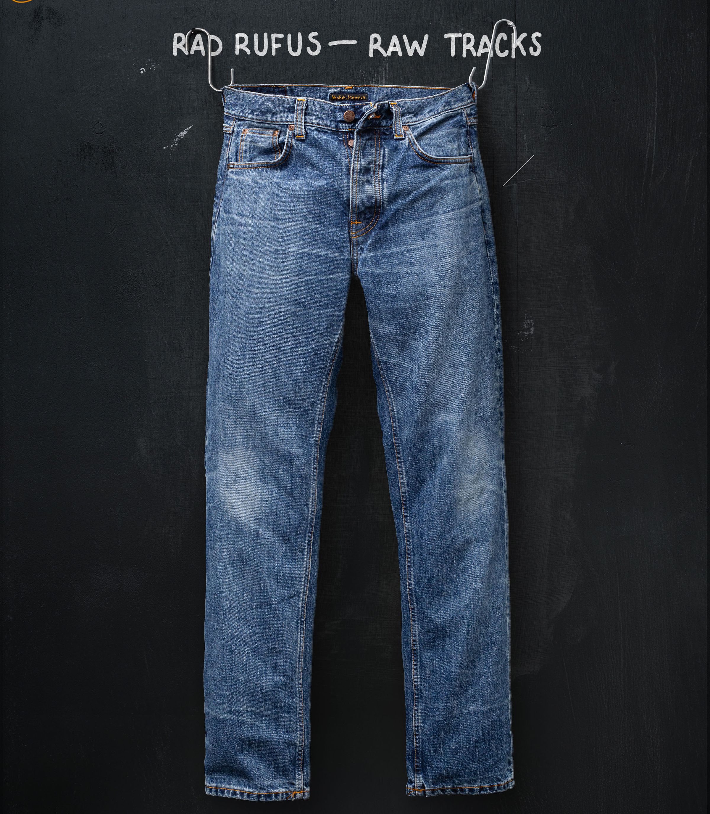 Faded blue jeans hanging against a dark background with "Rad Rufus - Raw Tracks" written above.