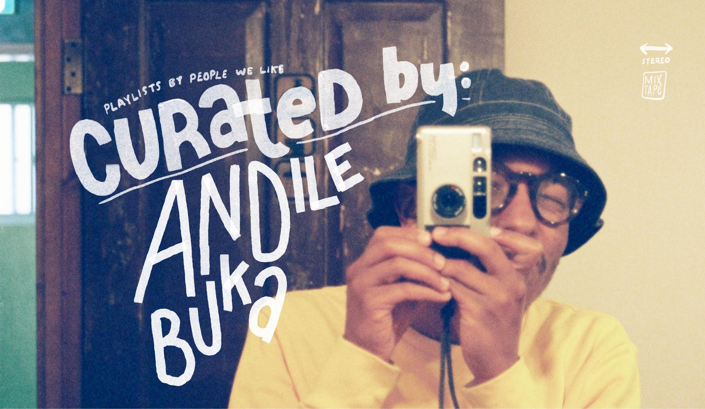 Person in a yellow sweater and bucket hat takes a mirror selfie with a camera. Text reads "Curated by: Andile Buka."