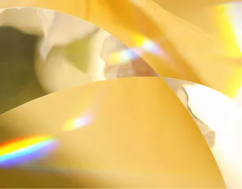 Abstract image with soft golden curves, rainbow light reflections, and blurred shapes, creating a warm and serene atmosphere.