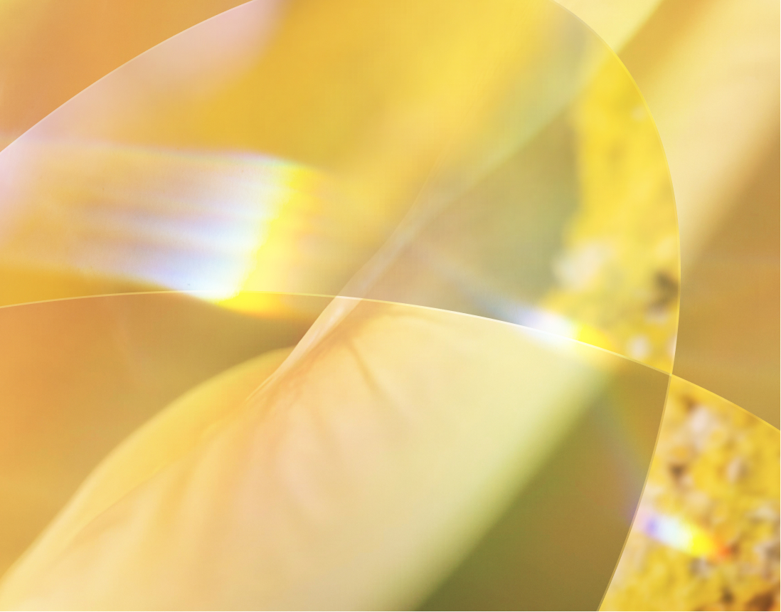 Abstract image with soft yellow and gold gradients, overlapping translucent shapes, and a touch of rainbow colors creating a warm, ethereal effect.
