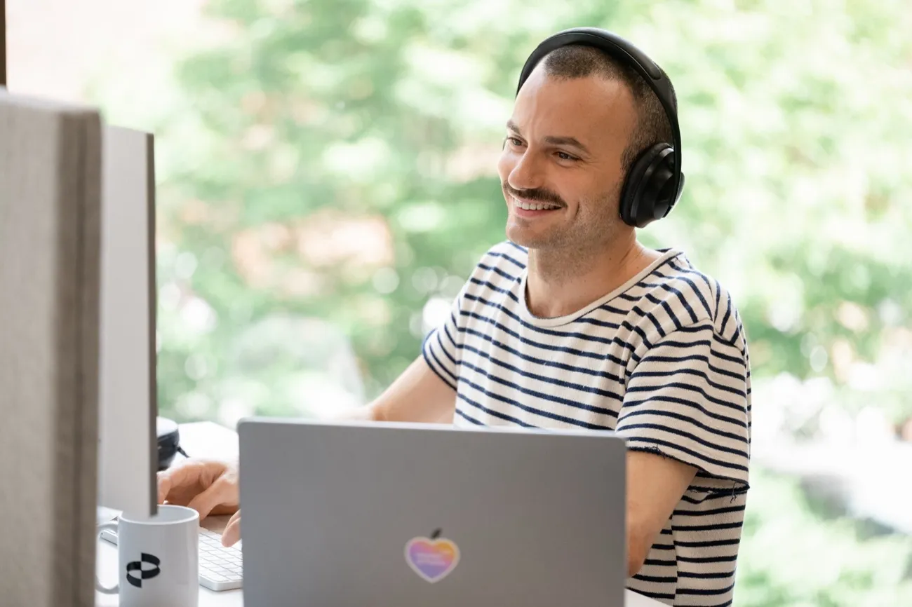 Man with headphones working at a laptop