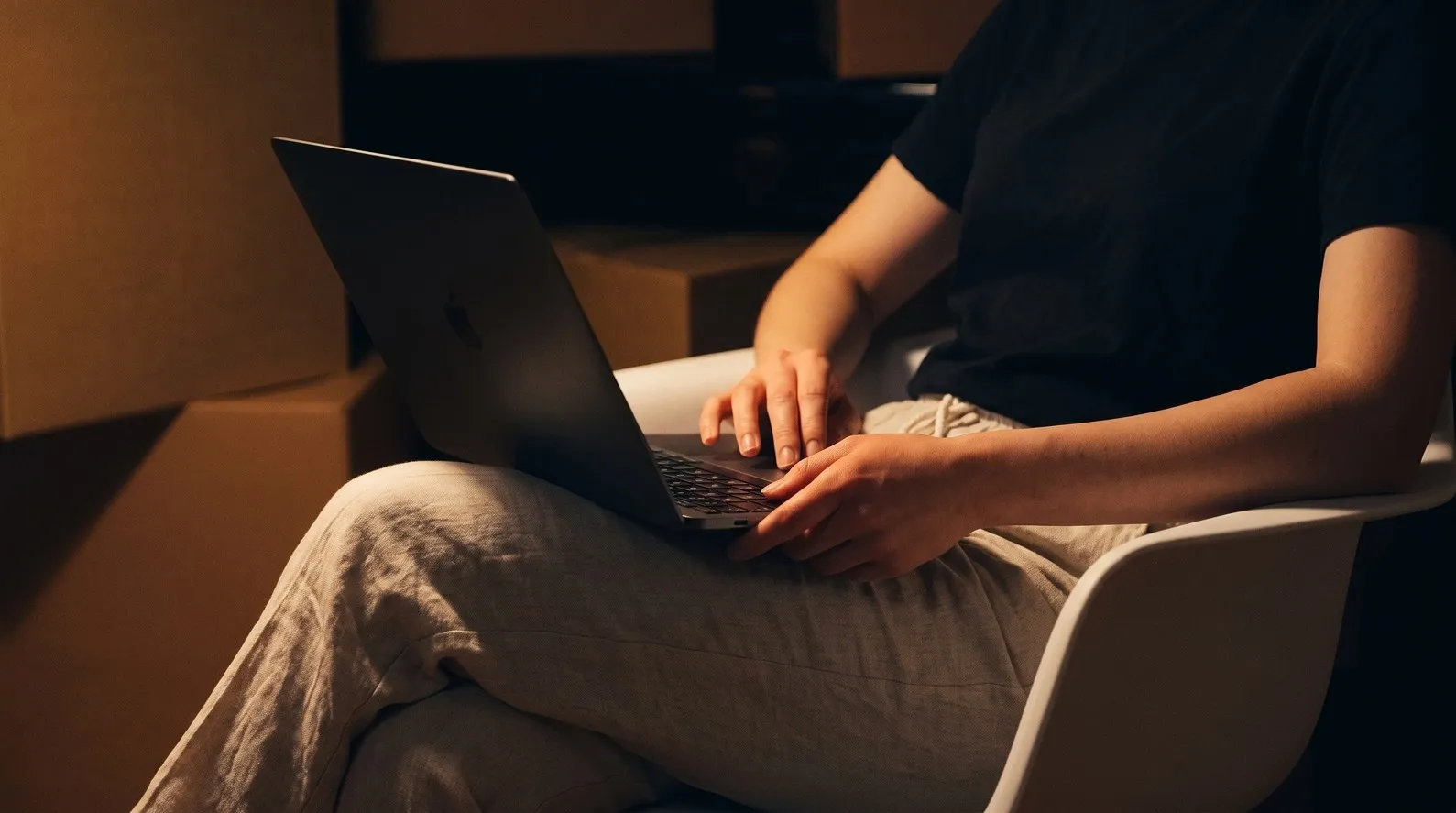 Person arbeitet mit dem Laptop auf dem Schoß