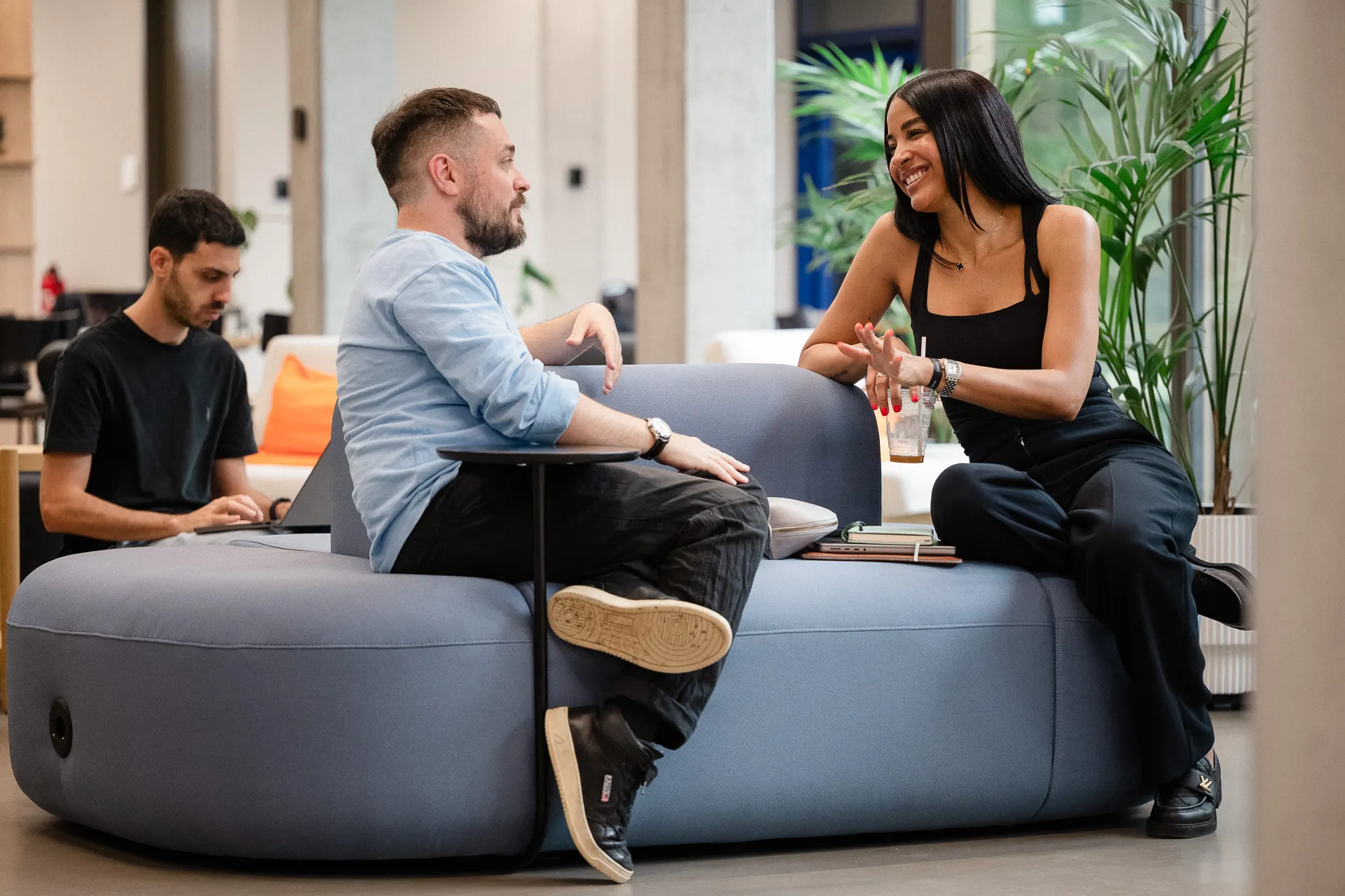 Three colleagues talking in the office lounge