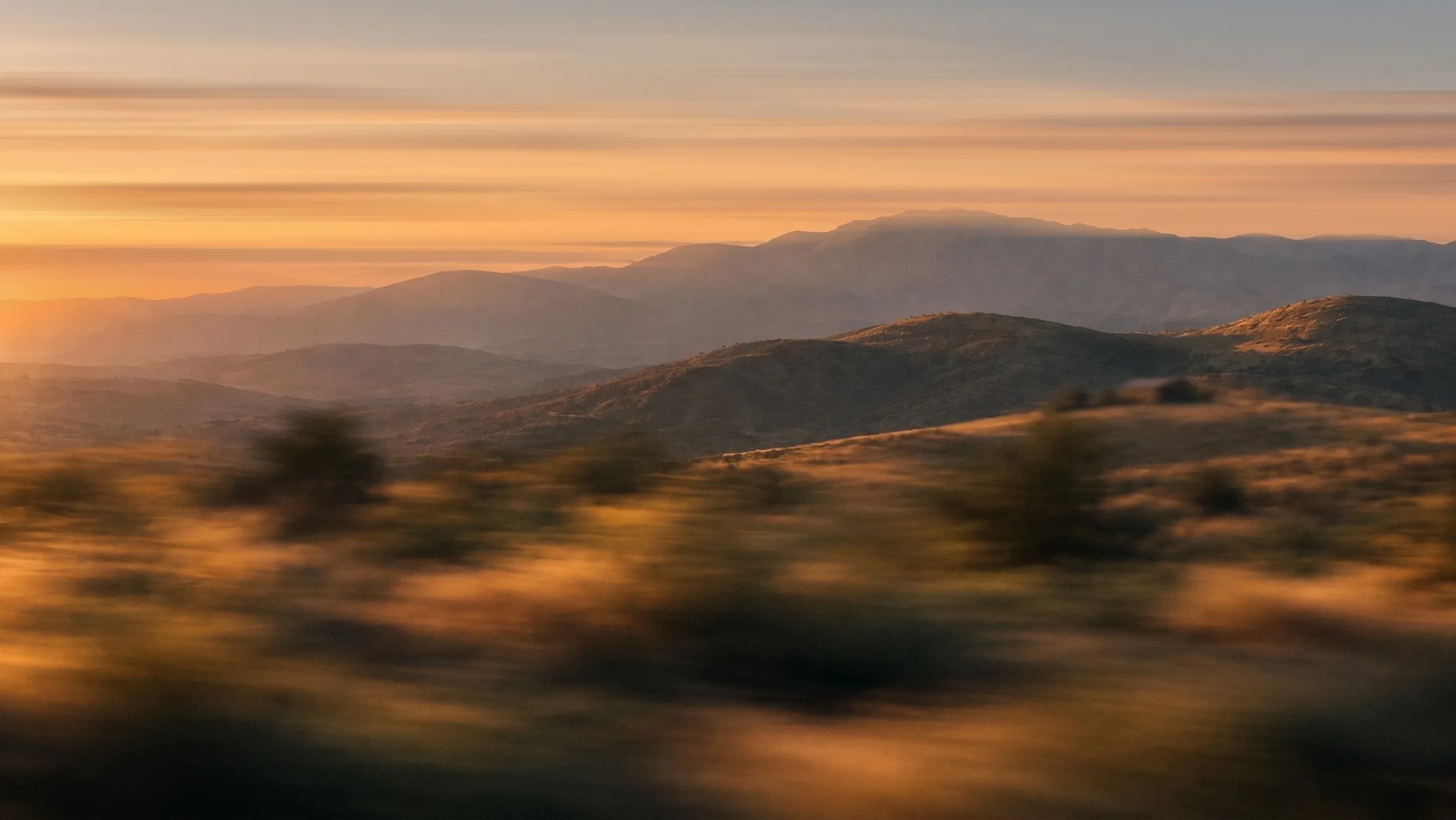 Rolling hills and mountains at sunset