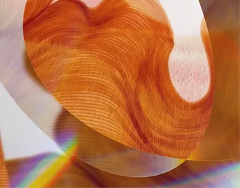 Abstract image with swirling orange and red patterns, overlapping translucent layers, and a hint of rainbow light effect at the bottom.
